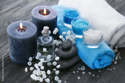 Spa still life with flowers and candlelight on wooden table closeup