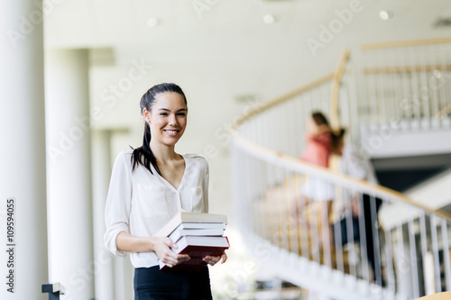 Beautiful woman holding books in a library