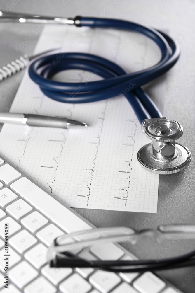 Cardiogram chart with medical stethoscope on table closeup Cardiogram chart with medical stethoscope on table closeup