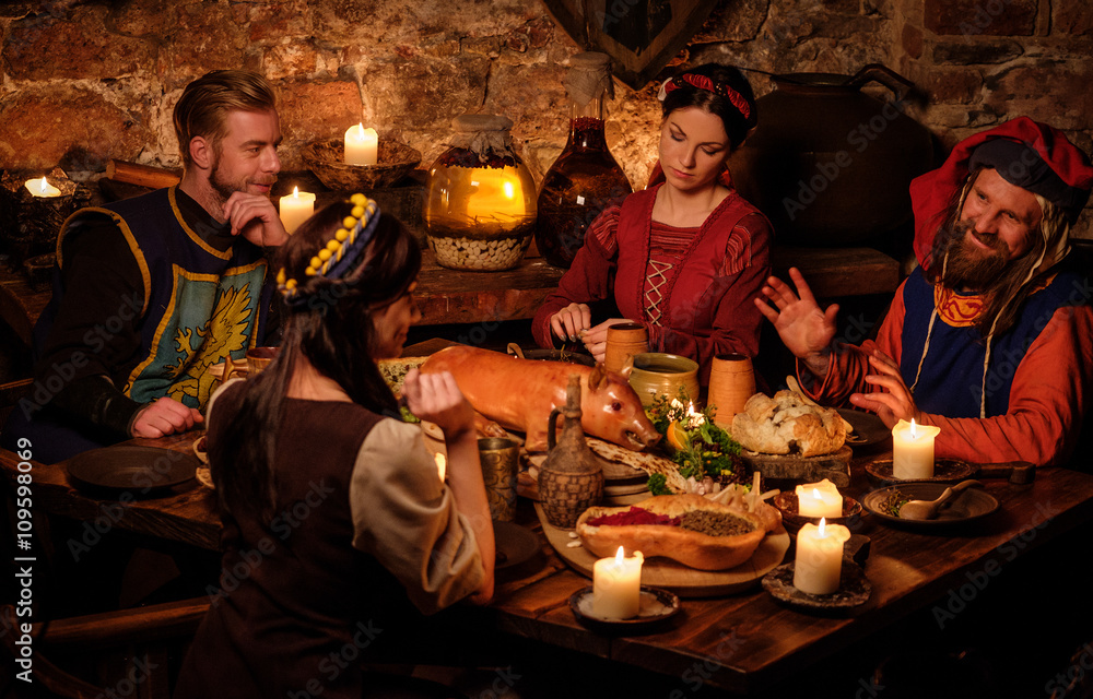 Medieval people eat and drink in ancient castle kitchen interior Medieval people eat and drink in ancient castle kitchen interior