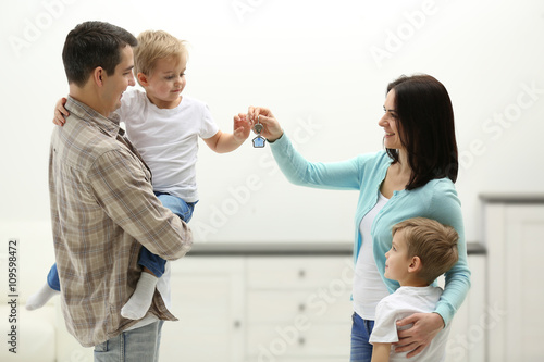 Happy family with key in ne...