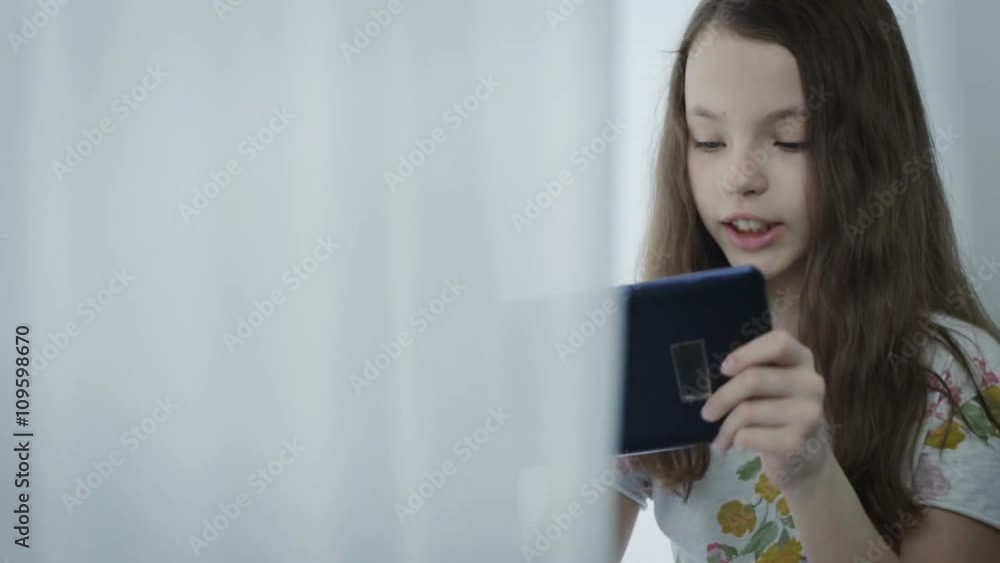 Emotional little girl plays a game on tablet. Emotional little girl plays a game on tablet.