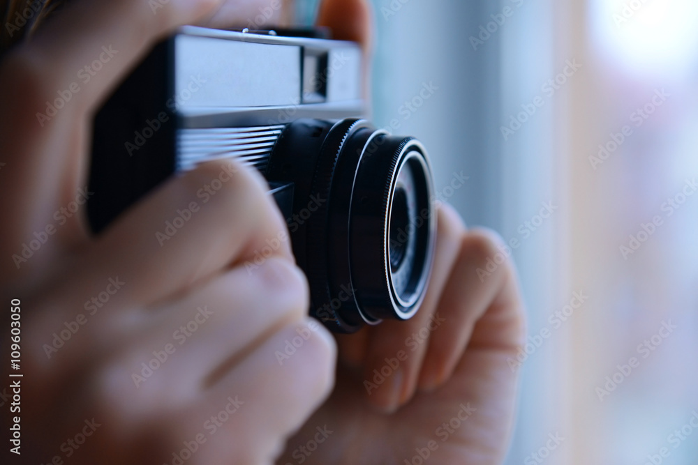 Female hands holding retro camera closeup
