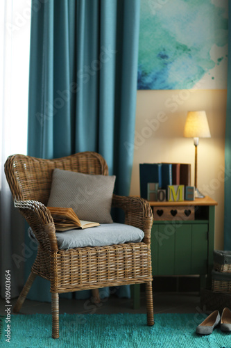 Design interior with wicker armchair and wooden nightstand indoors
