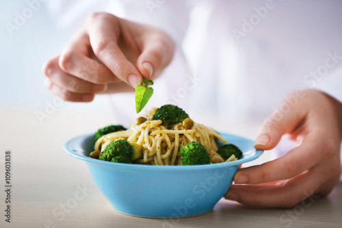 Chef hands preparing delicious cold pasta salad closeup