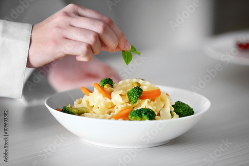 Wallpaper Mural Chef hands preparing delicious cold pasta salad on the table closeup Torontodigital.ca