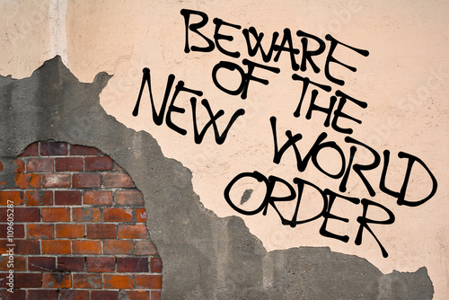 Schilderij op canvas Handwritten graffiti Beware Of The New World Order sprayed on the wall, anarchist aesthetics