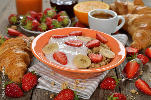 Muesli with yogurt  croissant and fresh strawberries