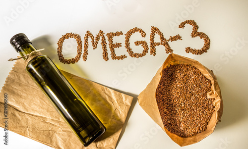 Здоровое питание. Льняное семя и бутылка льняного масла на светлом фоне.