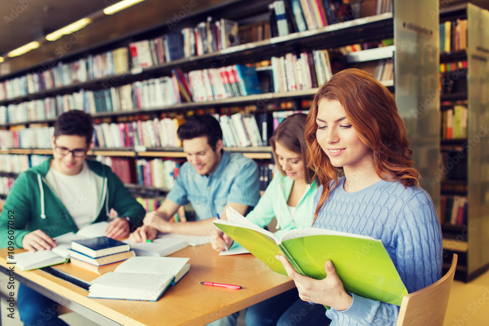 happy students reading books in library happy students reading books in library