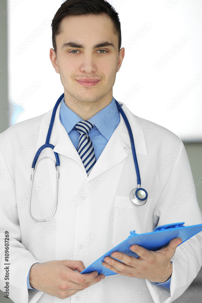 A male doctor with stethoscope holding a clipboard, close-up A male doctor with stethoscope holding a clipboard, close-up