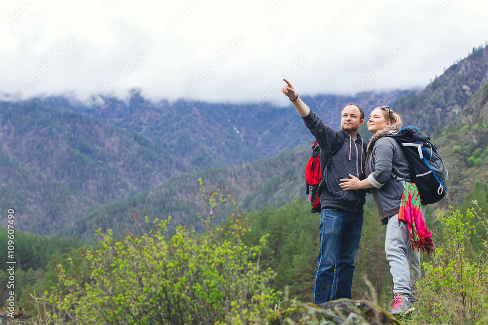 Young couple in the mountains with backpacks