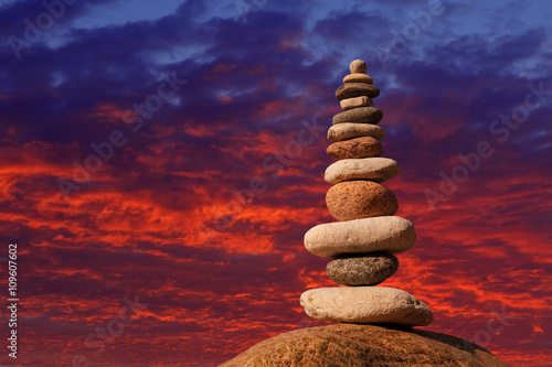 Concept of harmony and balance. Rock Zen on sunset background.
