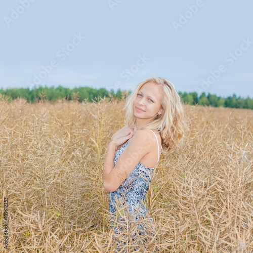 beautiful blonde walks into the field. portrait of a beautiful blonde in a field
