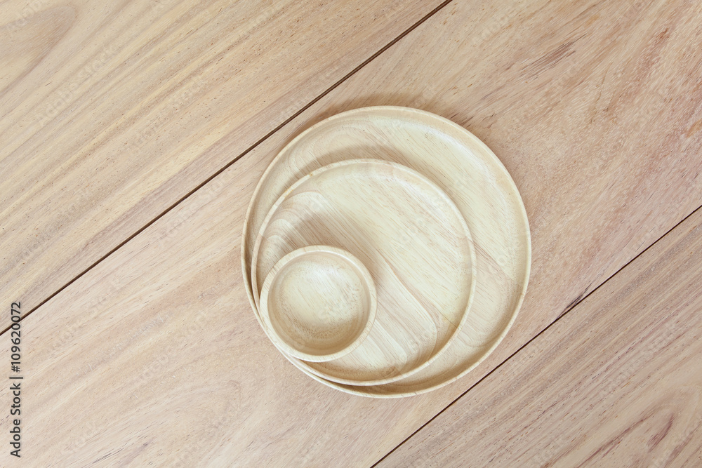 Empty round wooden plate on wood table background Empty round wooden plate on wood table background