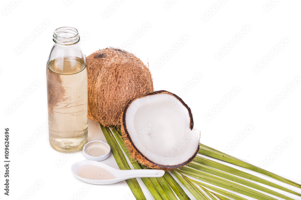 Cold pressed extra virgin coconut oil in one bottle with coconut fruits in white background Cold pressed extra virgin coconut oil in one bottle with coconut fruits in white background