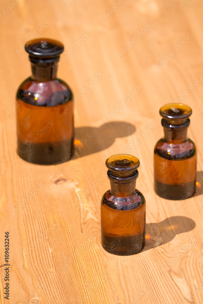 Small brown glass bottles on wooden board