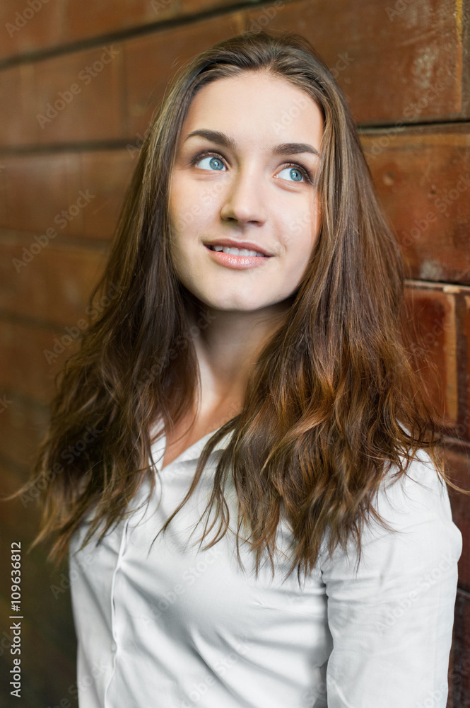 Pretty female girl in white shirt on brick background Pretty female girl in white shirt on brick background