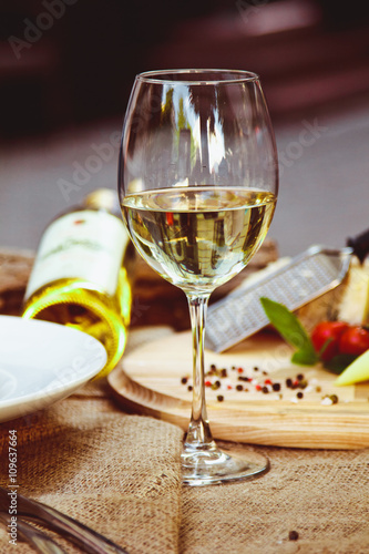 A glass of white wine stands on a table in the restaurant