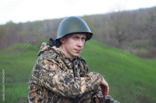 Солдат в каске на зеленом поле