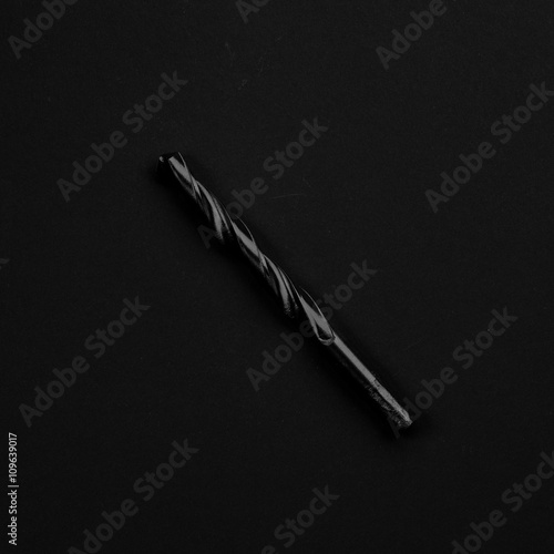 Black & white drill bit isolated on black background. Symbolic r