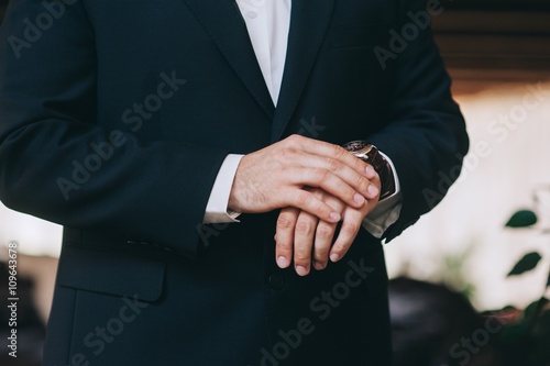 Man fastens his cuff links close-up. Businessman or fiance prepa