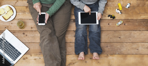 Mother and son using tablet and laptop