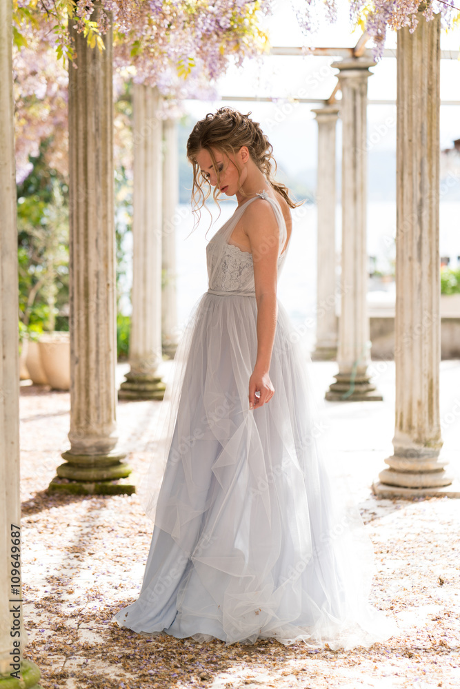 Fototapeta premium young bride in a wedding dress poses on the terrace