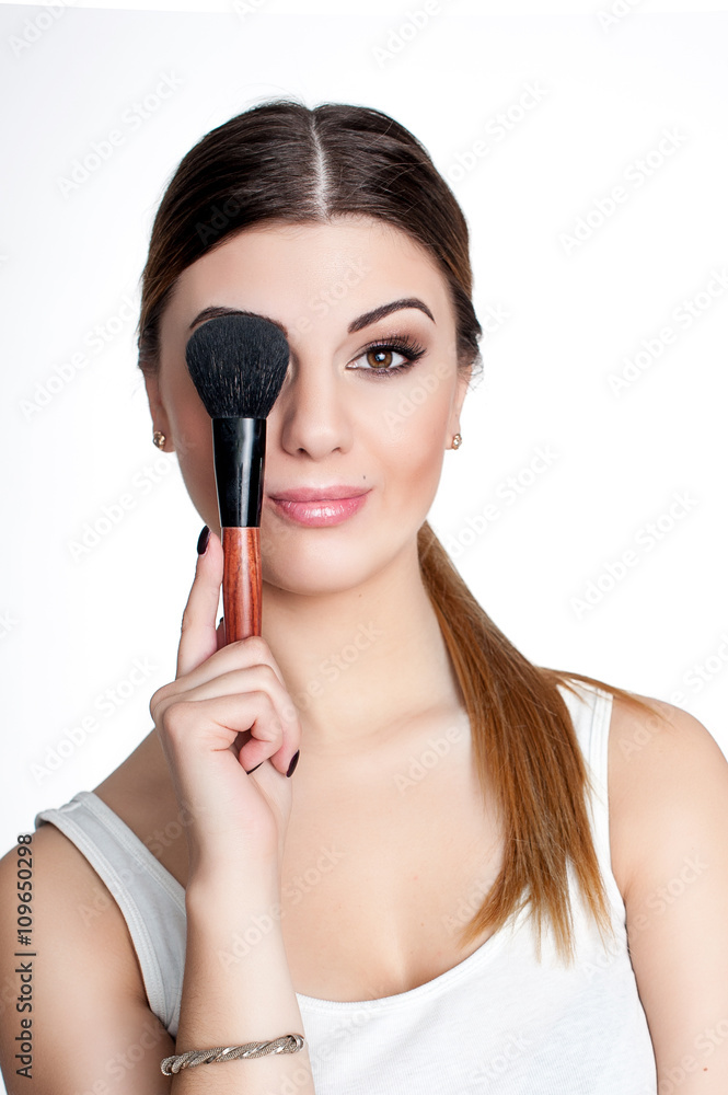 Beauty Girl make up artist with Makeup Brush. Bright Holiday Make-up for Brunette Woman with Brown Eyes. Beautiful Face. Makeover. Perfect Skin. Applying Makeup Beauty Girl make up artist with Makeup Brush. Bright Holiday Make-up for Brunette Woman with Brown Eyes. Beautiful Face. Makeover. Perfect Skin. Applying Makeup