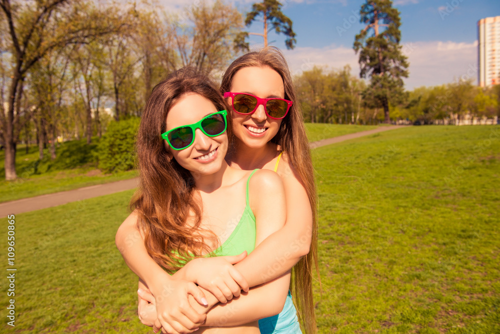 Portrait of beautiful girls in glasses embracing in the park Portrait of beautiful girls in glasses embracing in the park