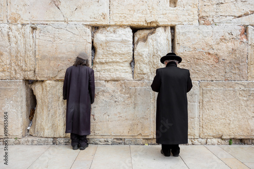 JERUSALEM, ISRAEL - MARCH 15, 2016: Two men praying at the men's section of the Wailing (Western) Wall in the old town Jerusalem (Israel)