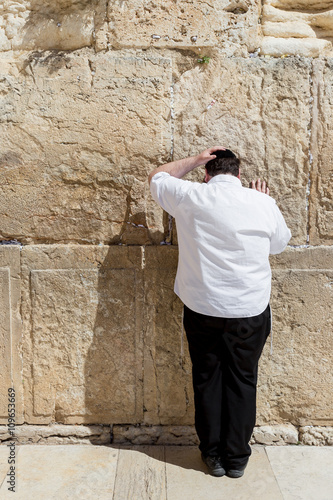 JERUSALEM, ISRAEL - MARCH 15, 2016: Man praying at the men's section of the Wailing (Western) Wall in the old town Jerusalem (Israel)