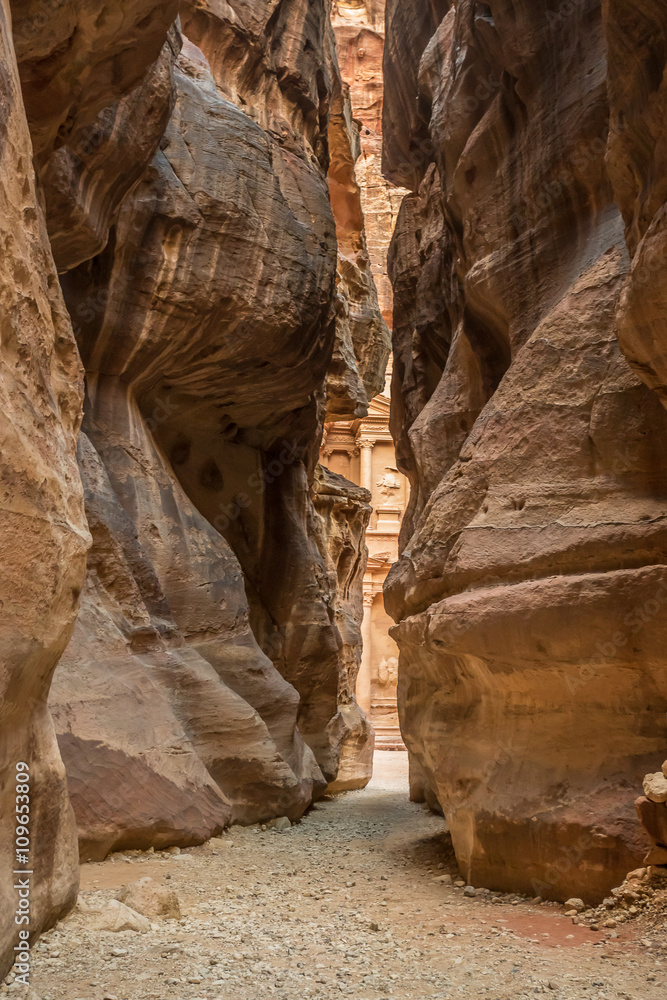 Hiking through the canyon in the ancient city of Petra (Jordan) - opening view of the famous Al-Khazneh (aka Treasury) Hiking through the canyon in the ancient city of Petra (Jordan) - opening view of the famous Al-Khazneh (aka Treasury)