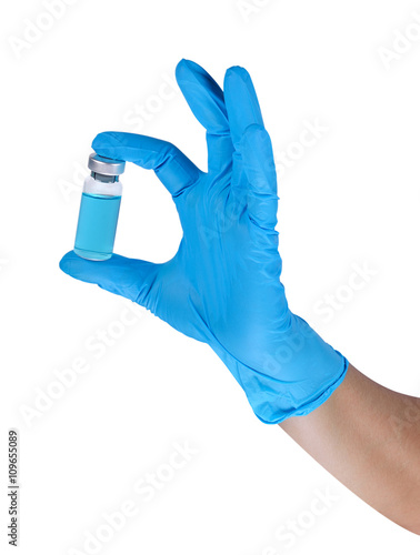 Hands of a medic wearing a blue latex gloves with liquid sample,