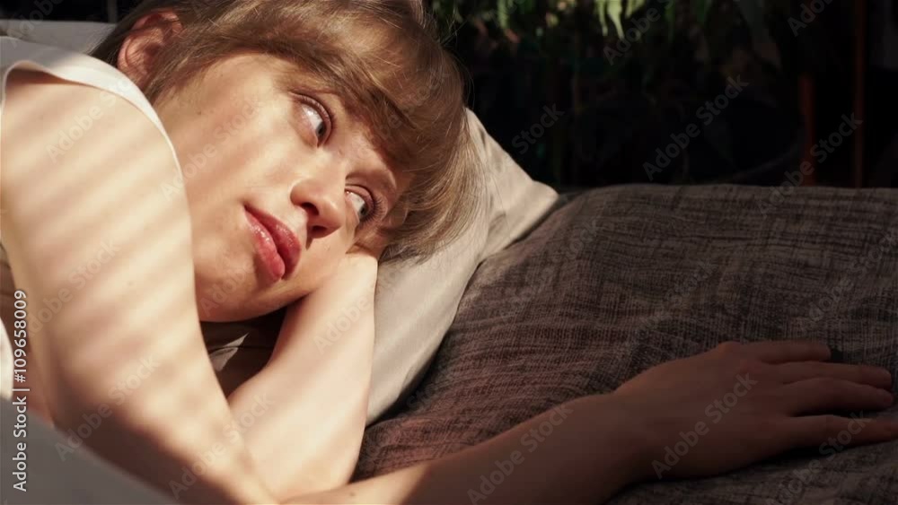 Cute sunny girl awakes in bed with phone in the morning and chating with friends Cute sunny girl awakes in bed with phone in the morning and chating with friends