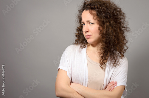 Quadro em tela Woman looks with suspicious crossed hands