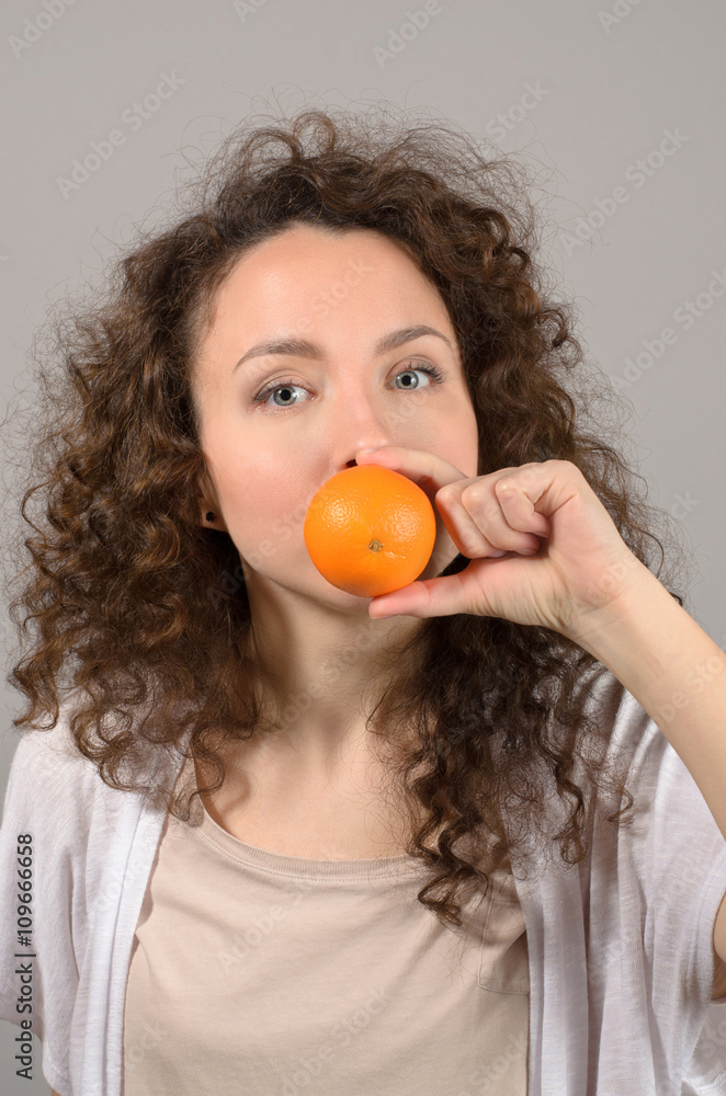 woman with tangerines near mouth woman with tangerines near mouth
