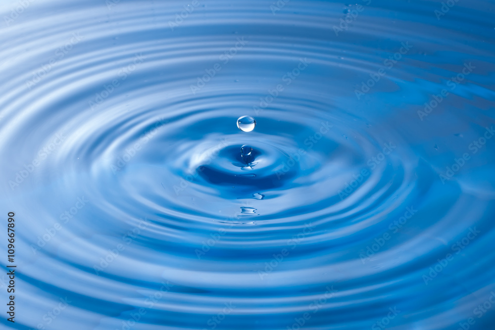 a water drop impact with water surface, causing rings on the sur a water drop impact with water surface, causing rings on the sur