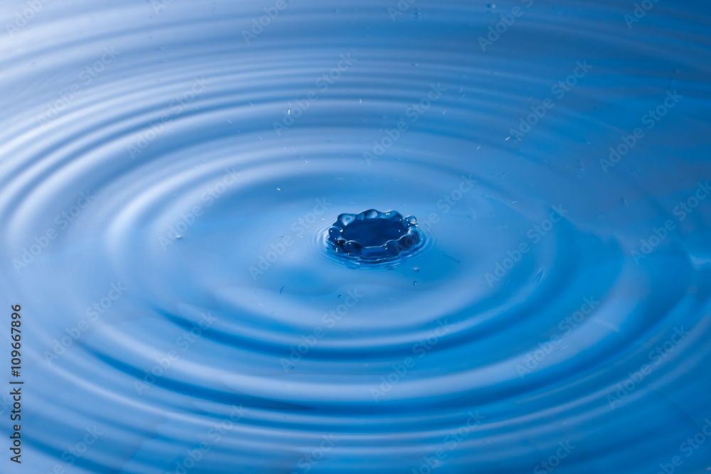 a water drop impact with water surface, causing rings on the sur