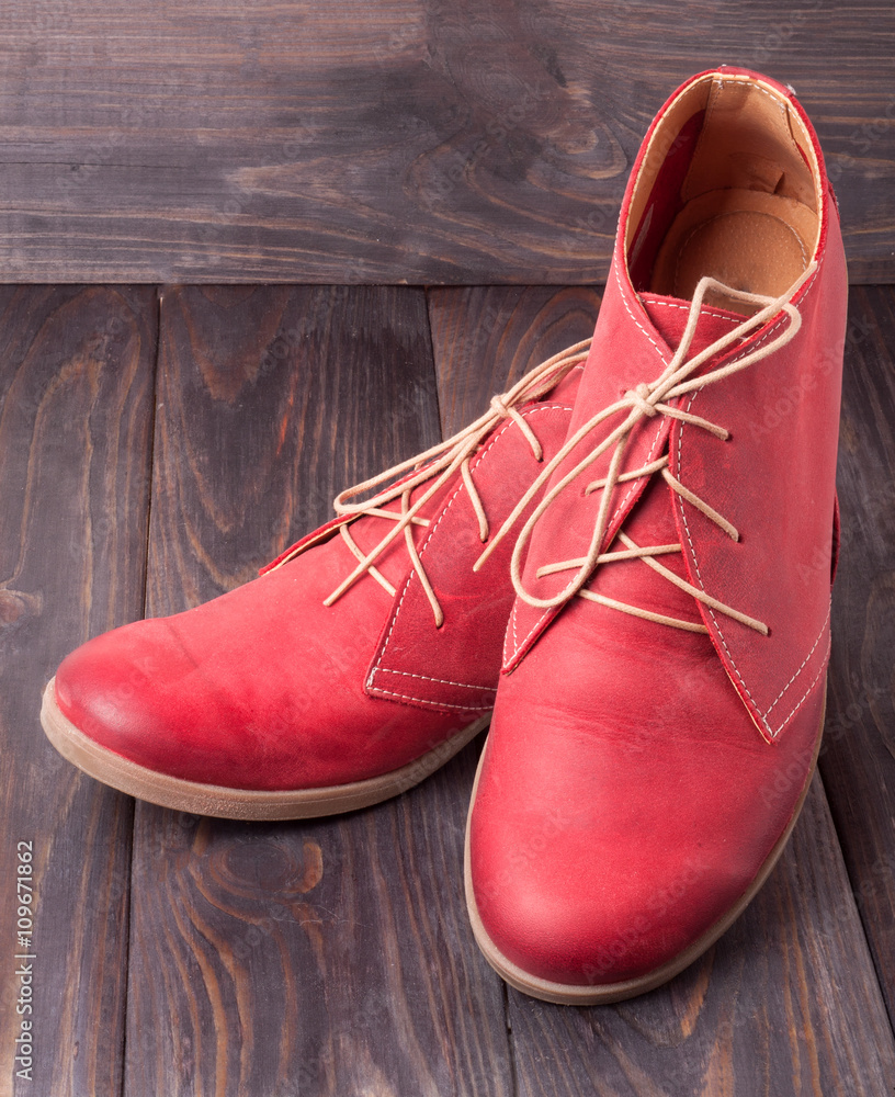 red women's leather shoes with laces on  wooden background