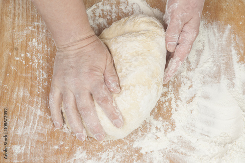 Women's hands preparing fresh yeast dough