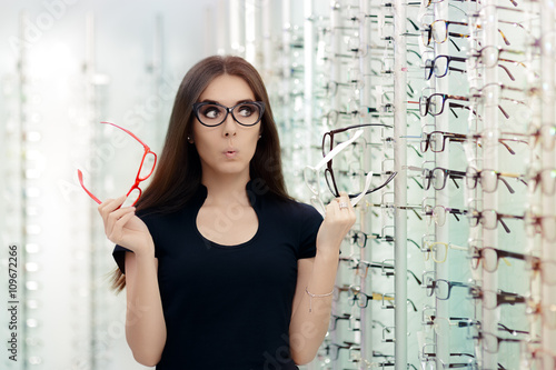 Fotografi Woman Choosing Eyeglasses Frames in Optical Store