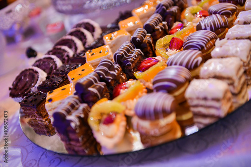 Different type of cakes on a plate and with side light
