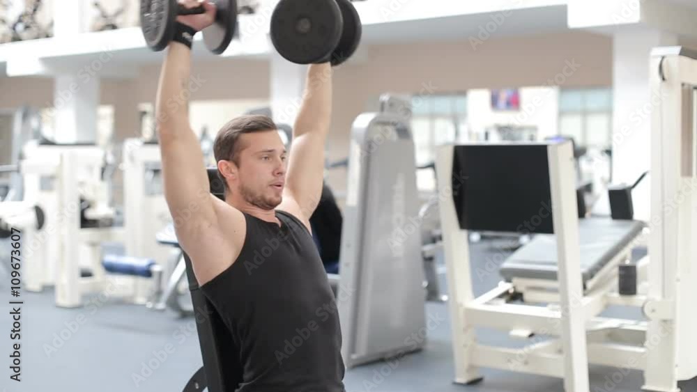 Man bodybuilder execute exercise with dumbbells in gym. Man bodybuilder execute exercise with dumbbells in gym.