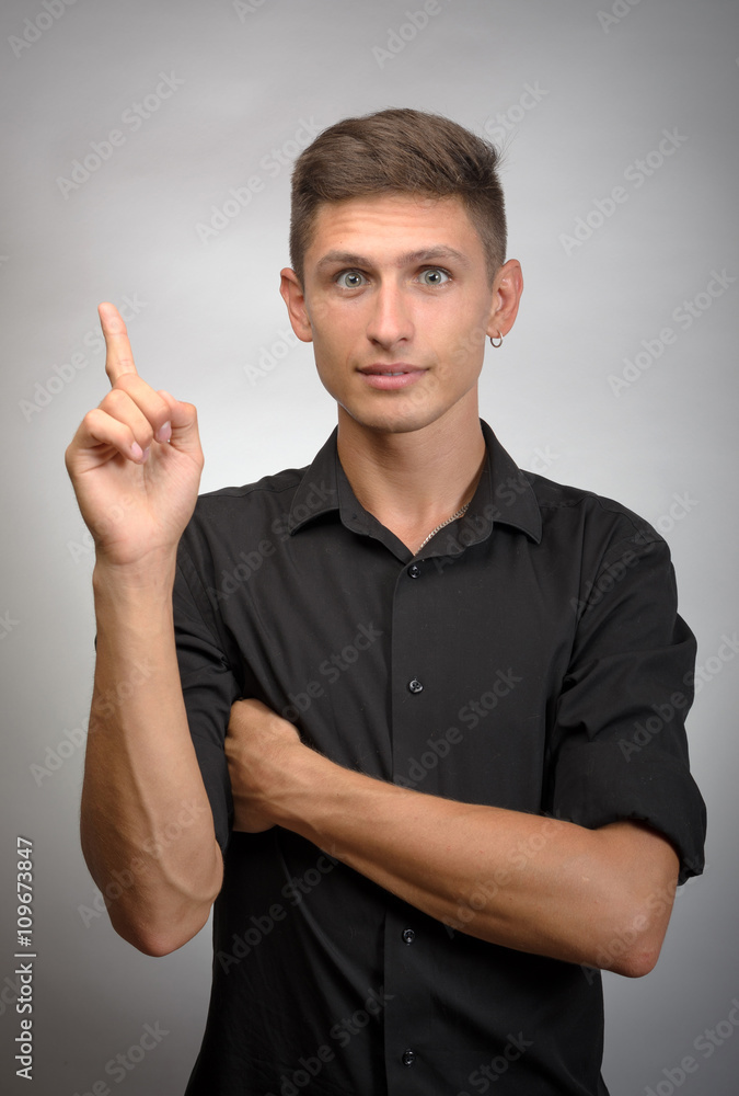 Business male pointing upwards and smiling at camera Business male pointing upwards and smiling at camera