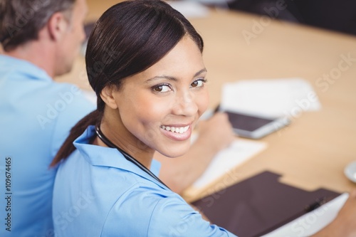 Happy female doctor sitting on conference room