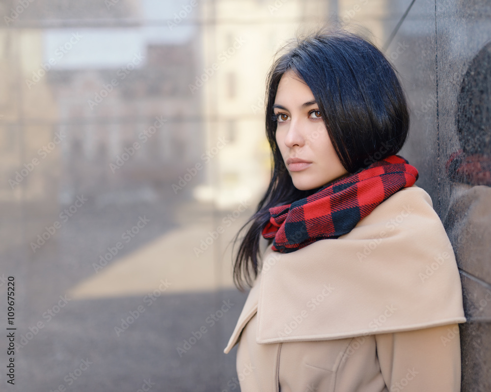 Young woman in a coat on the street.