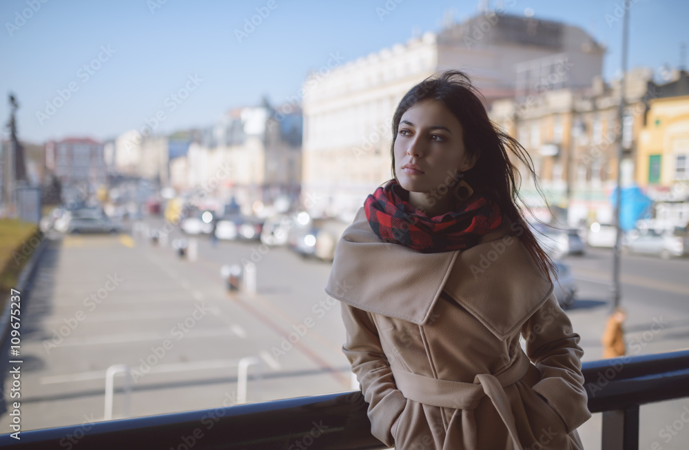 Young woman in a coat on the street.