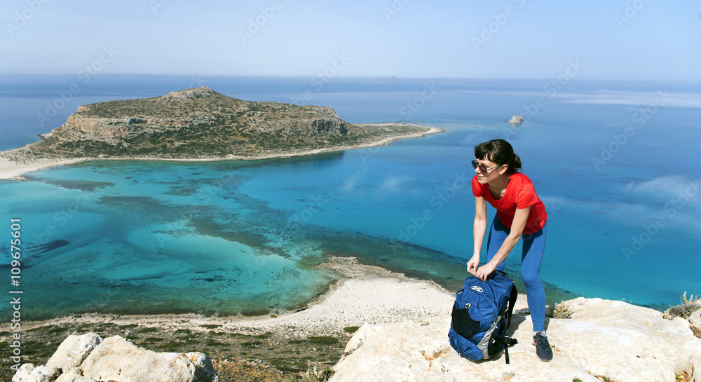 a young girl fastening the backpack in the mountains