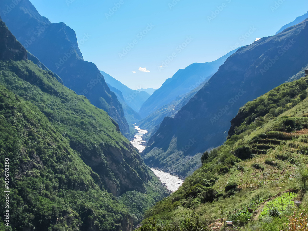 Waterfall and Mountain at Tiger Leaping Gorge. Located 60 kilometers north of Lijiang City, Yunnan Province, China.